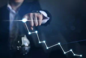 Person in front of a computer showing growth charts and statistics on screen.